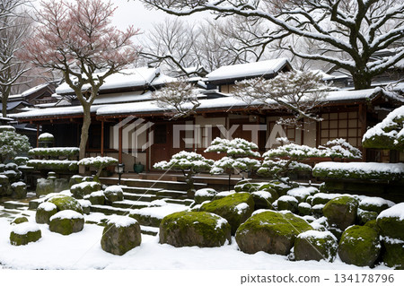 日式庭園，苔蘚覆蓋的石板路，以及被雪覆蓋的盆景樹。 134178796