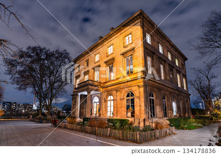 Historic Chateau de Saint-Ouen stands illuminated at night near Paris, France. 19th-century castle features classical architecture and stone facade in Saint-Ouen-sur-Seine 134178836