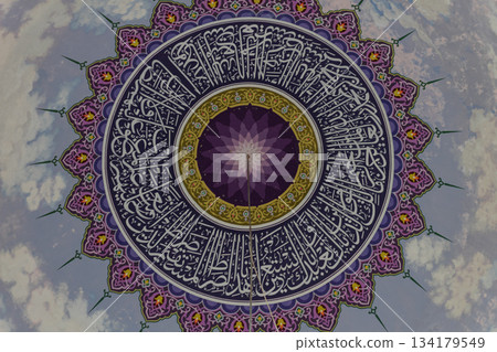 Close up of beautiful ornate mosque dome calligraphy and vivid geometric patterns Close up of beautiful ornate mosque dome calligraphy and vivid geometric patterns 134179549