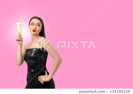 Woman in a sequined dress sips champagne elegantly 134180249