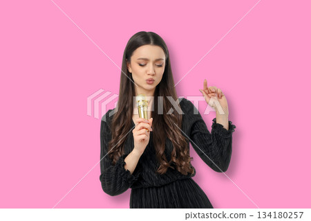 Woman in a black dress singing joyfully with a microphone Woman in a black dress singing joyfully with a microphone 134180257