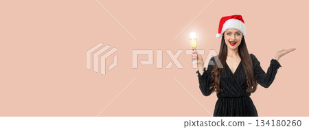 Woman in black dress holding a champagne glass smiling happily Woman in black dress holding a champagne glass smiling happily 134180260