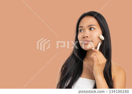 Woman applies skin care tool for beauty in spa area Woman applies skin care tool for beauty in spa area 134180280