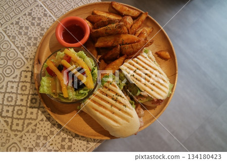 Panini with potato wedges and salad 134180423
