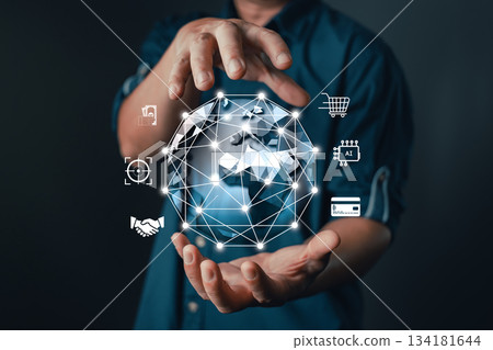 businessman hold a glowing digital globe with interconnected icons representing AI, finance, e-commerce, targeting, handshake, and global connectivity, modern digital transformation and technology. businessman hold a glowing digital globe with interconnected icons representing AI, finance, e-commerce, targeting, handshake, and global connectivity, modern digital transformation and technology. 134181644