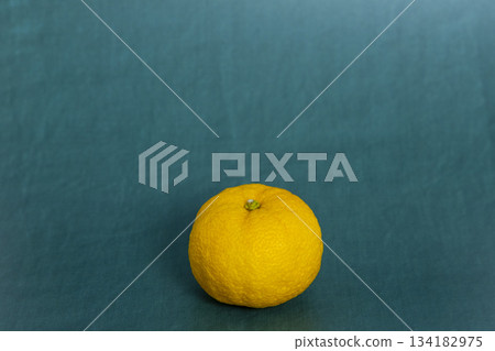 A single yuzu placed on a blue-green background - an image of the winter solstice and citrus fruits A single yuzu placed on a blue-green background - an image of the winter solstice and citrus fruits 134182975