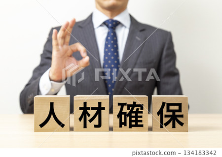 A businessman making an OK pose with a block that says "Human Resources Securing" A businessman making an OK pose with a block that says "Human Resources Securing" 134183342