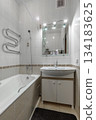 Compact Bright Bathroom Interior with Bathtub and Sink Cabinet 134183625
