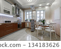 Bright Modern Kitchen Interior with Dining Table and Cabinets 134183626