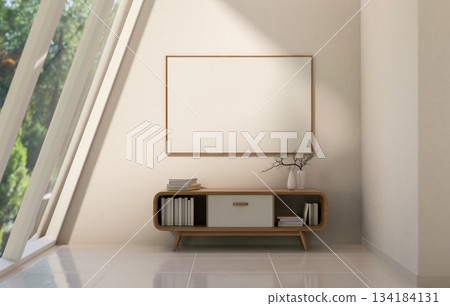 A frame on wall over wooden table and sunlight through sloped glass roof window in tiles floor room. 134184131