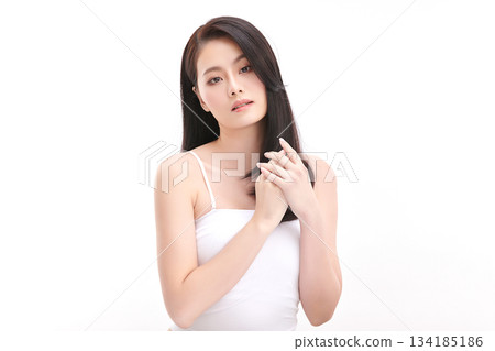 A beautiful young Asian woman with clean, fresh skin against a white background. Skincare, facial treatment, cosmetology, beauty, and spa. An elegant portrait of an Asian woman. 134185186