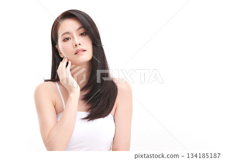A beautiful young Asian woman with clean, fresh skin against a white background. Skincare, facial treatment, cosmetology, beauty, and spa. An elegant portrait of an Asian woman. 134185187
