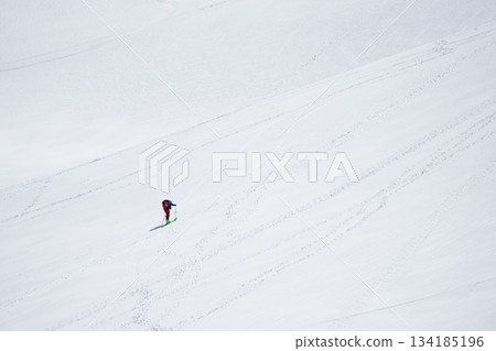 Backcountry skiers climbing the slopes of a vast snowy mountain Backcountry skiers climbing the slopes of a vast snowy mountain 134185196