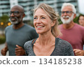 A group of active adults jogging outdoors, smiling and energized, enjoying a healthy lifestyle together in a bright and motivating urban environment. 134185238