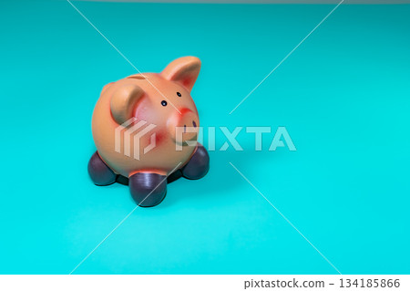 A piggy bank, a symbol of savings, set against a solid backdrop, evokes financial security amid economic downturns. 134185866
