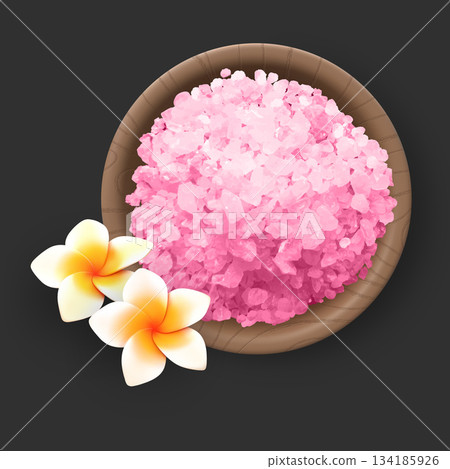 Large crystals of pink Himalayan salt in a wooden bowl with plumeria flowers on a dark background. 134185926
