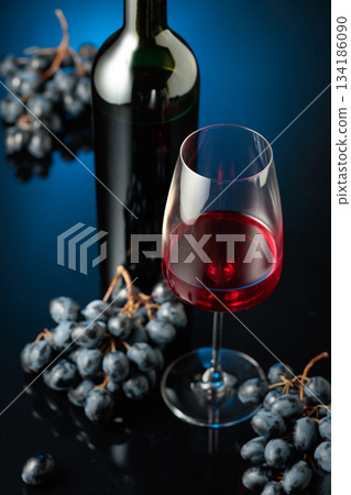Red wine and juicy blue grapes. 134186090