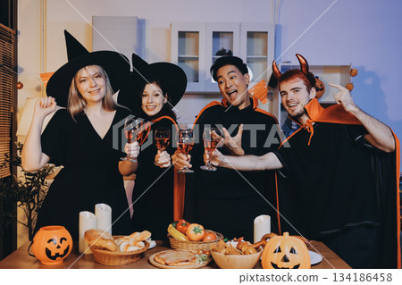 Friends enjoying a Halloween party at a bar making a toast Friends enjoying a Halloween party at a bar making a toast 134186458