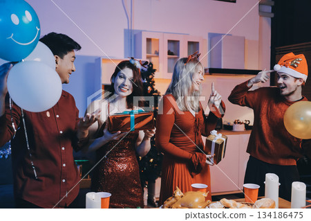 Festive Office Christmas Party with Delicious Food. A beautifully decorated office space with Christmas trees and festive lights, set up for a holiday party. 134186475