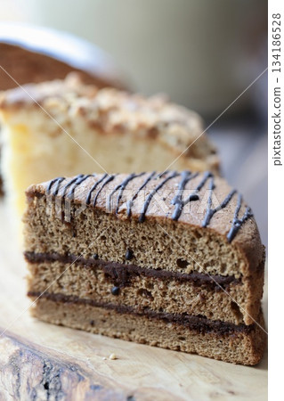 Three types of cut cakes arranged on a wooden board Three types of cut cakes arranged on a wooden board 134186528