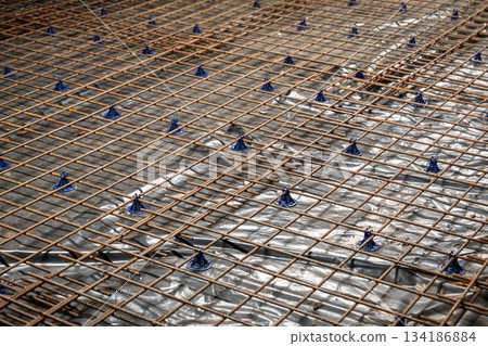 Reinforcement Steel Rebar Grid with Plastic Spacers on Vapor Barrier for Concrete Slab Work Reinforcement Steel Rebar Grid with Plastic Spacers on Vapor Barrier for Concrete Slab Work 134186884