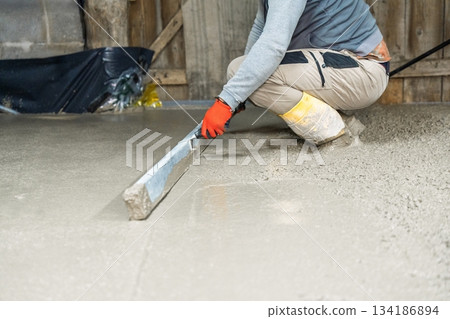 Craftsman Smoothing Fresh Concrete Surface with Hand Tool for Perfect Flooring Finish Craftsman Smoothing Fresh Concrete Surface with Hand Tool for Perfect Flooring Finish 134186894