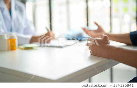 A patient explaining to a doctor. 134186941