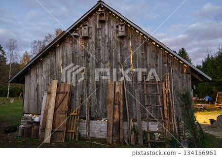 Rustic Wooden Barn with Birdhouses and Ladders in the Countryside at Twilight 134186961