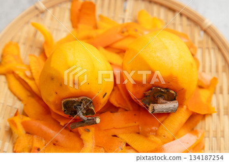 Peeled persimmons for drying and the peel after peeling 134187254