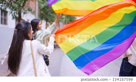 Young women celebrating diversity holding rainbow flags Young women celebrating diversity holding rainbow flags 134187599