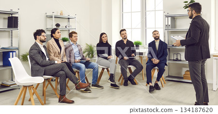 Manager coach speaking at corporate group meeting in office. Manager coach speaking at corporate group meeting in office. 134187620