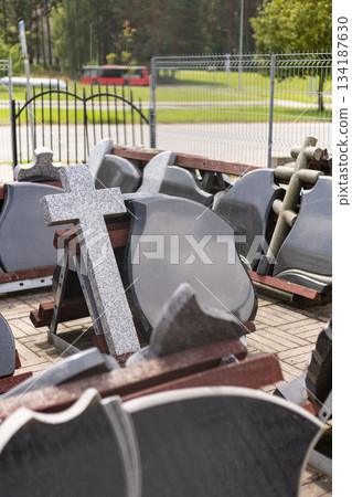 A variety of tombstones are displayed in an outdoor area, showcasing different shapes and sizes. The scene promotes grave markers available for purchase to honor loved ones A variety of tombstones are displayed in an outdoor area, showcasing different shapes and sizes. The scene promotes grave markers available for purchase to honor loved ones 134187630