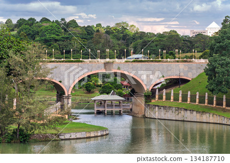 Seri Gemilang Bridge, a stone arch bridge, spanning across water with surrounding greenery in Putrajaya, Malaysia. Seri Gemilang Bridge, a stone arch bridge, spanning across water with surrounding greenery in Putrajaya, Malaysia. 134187710