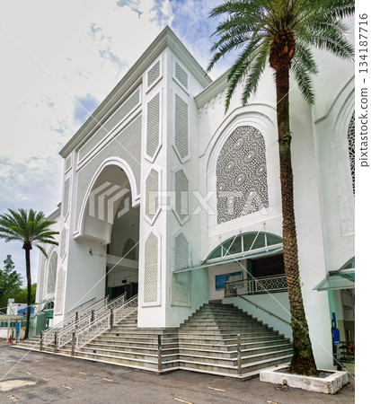 Al-Bukhari Mosque, Kuala Lumpur, Malaysia. White Islamic architecture with intricate patterns and palm trees. Al-Bukhari Mosque, Kuala Lumpur, Malaysia. White Islamic architecture with intricate patterns and palm trees. 134187716