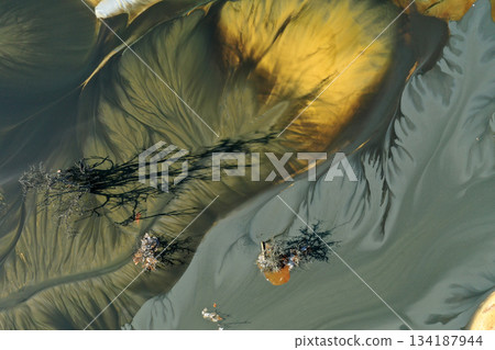 Surreal aerial natural patterns. Residual gold mining leach waters polluting the environment Surreal aerial natural patterns. Residual gold mining leach waters polluting the environment 134187944