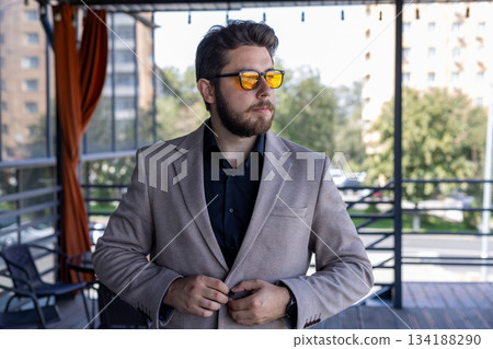 Confident businessman sitting in a modern cafe estaurant, portrait Confident businessman sitting in a modern cafe estaurant, portrait 134188290