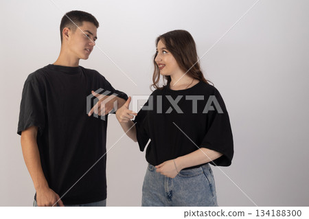 Young man and woman talking or posing together in black t-shirts Young man and woman talking or posing together in black t-shirts 134188300