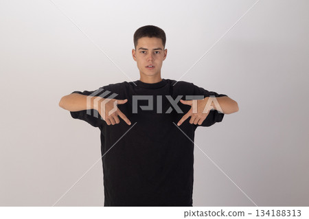 Young man in black t-shirt adjusting his collar, casual pose Young man in black t-shirt adjusting his collar, casual pose 134188313