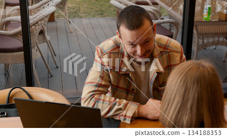 Happy woman looking out of a window while taking a break from work or study 134188353