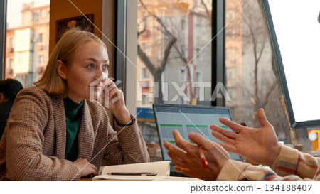Woman in a cafe talking to a man, gesturing with her hand for emphasis 134188407