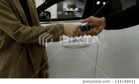 Close-up of a man's hands on the steering wheel, driving a new car Close-up of a man's hands on the steering wheel, driving a new car 134188411