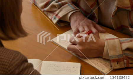 Two people discussing business or education plans across a small table Two people discussing business or education plans across a small table 134188422