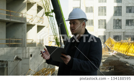 Architect engineer with tablet inspecting a construction site. Professional 134188595