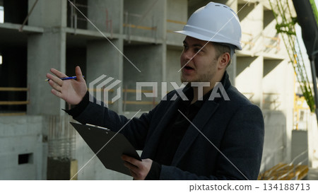 Construction manager explains project details to a team member on site Construction manager explains project details to a team member on site 134188713