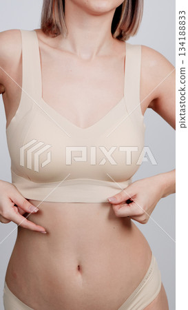 Close-up on a woman's body in nude-colored seamless underwear Close-up on a woman's body in nude-colored seamless underwear 134188833