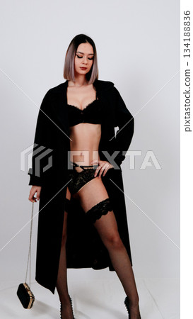 Fashionable woman in black lingerie and a long, dramatic cardigan Fashionable woman in black lingerie and a long, dramatic cardigan 134188836