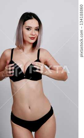 Attractive woman in black underwear with arms raised behind her head 134188860