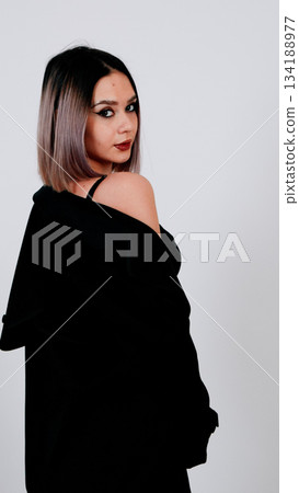Glamorous young woman posing in black lingerie and a shoulder-draped robe 134188977