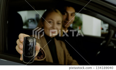 Happy couple sitting in car and celebrating new purchase Happy couple sitting in car and celebrating new purchase 134189040
