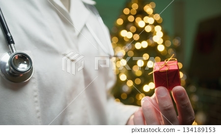 Health and Merry Christmas from a Male Doctor in Hospital Against Tree Health and Merry Christmas from a Male Doctor in Hospital Against Tree 134189153